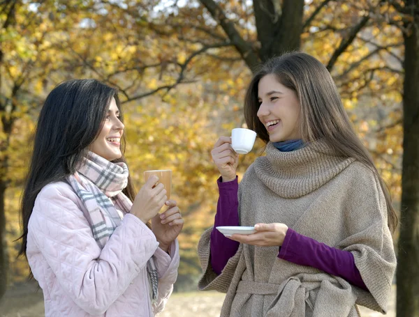 Buitenshuis hete herfst jonge vrouwen genieten van en het drinken van koffie. — Stockfoto