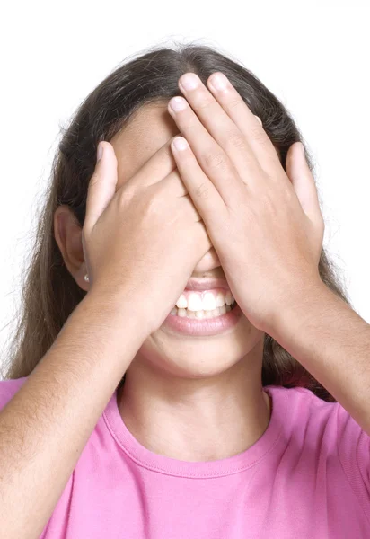 Surpreendido menina pequena retrato sorrindo e cobrindo seus olhos no fundo branco . — Fotografia de Stock