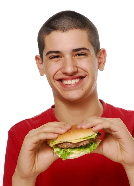 Junges Kind hält und isst einen Hamburger auf weißem Hintergrund. — Stockfoto