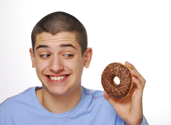 Liten pojke holding och äta en choklad donuts på vit bakgrund. — Stockfoto