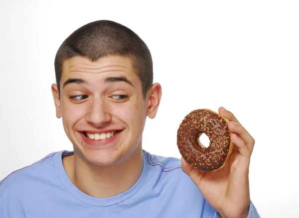 Niño sosteniendo y comiendo una rosquilla de chocolate sobre fondo blanco . — Foto de Stock