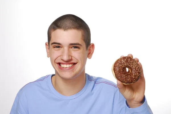 Niño sosteniendo y comiendo una rosquilla de chocolate sobre fondo blanco . — Foto de Stock