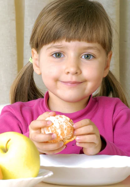 Menina comendo tangerina fresca — Fotografia de Stock