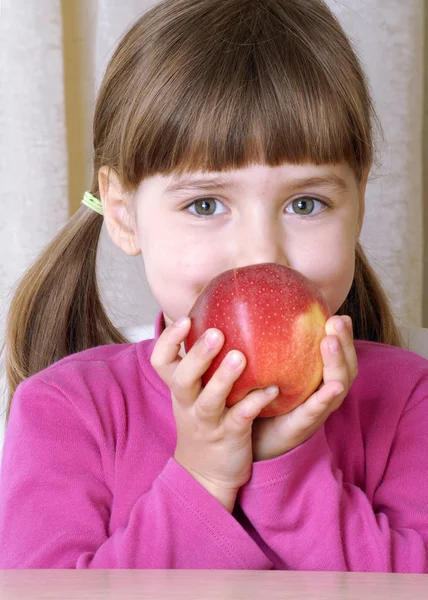 Liten flicka stående äta färskt rött äpple. — Stockfoto