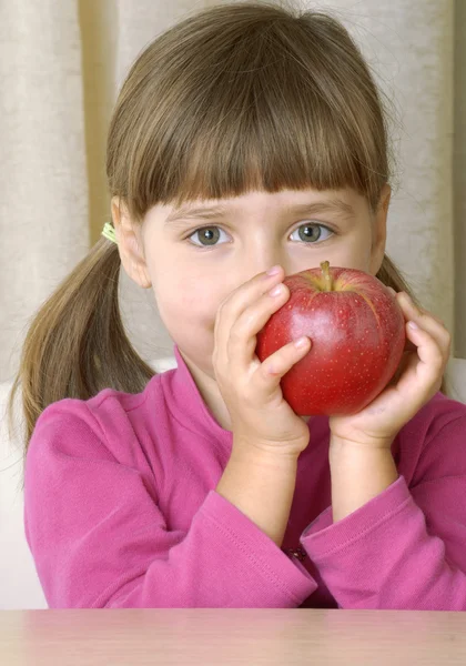 Liten flicka stående äta färskt rött äpple. — Stockfoto