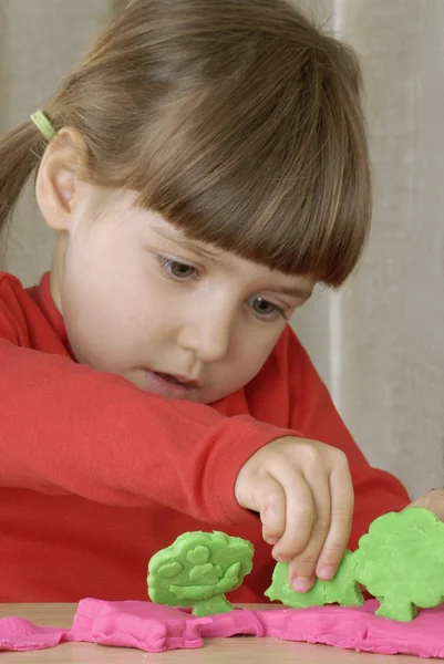 Kleines Mädchen spielt mit einem Ton — Stockfoto