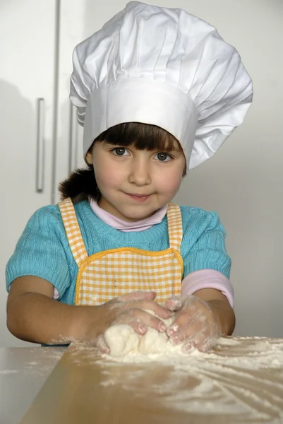 Ragazzina che cucina una pizza in cucina.Ragazzino in cucina . — Foto Stock