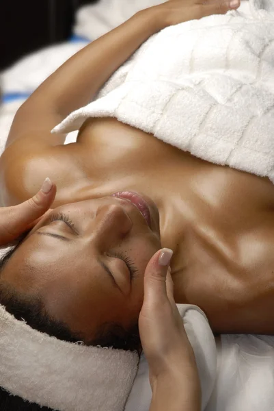 Hermosa joven afroamericana recibiendo un tratamiento facial en el salón de belleza . — Foto de Stock