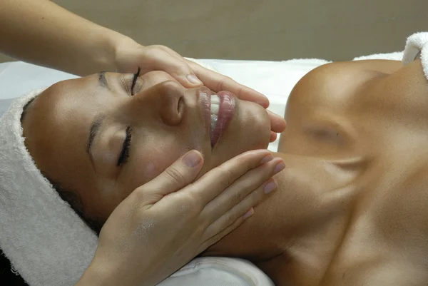 Hermosa joven afroamericana recibiendo un tratamiento facial en el salón de belleza . — Foto de Stock