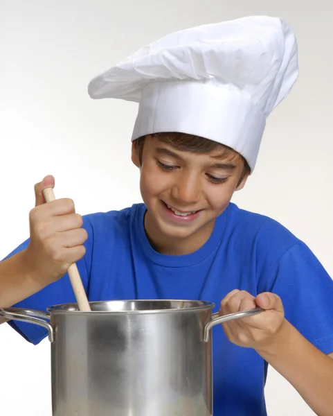 Malé dítě, vaření na kovové pánvi drží lžíci, dítě malý kuchař, vaření, vaření děti. — Stock fotografie