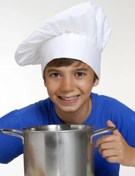 Niño pequeño cocinando en una sartén metálica sosteniendo una cuchara, niño cocinero cocinando, cocinando niños . — Foto de Stock