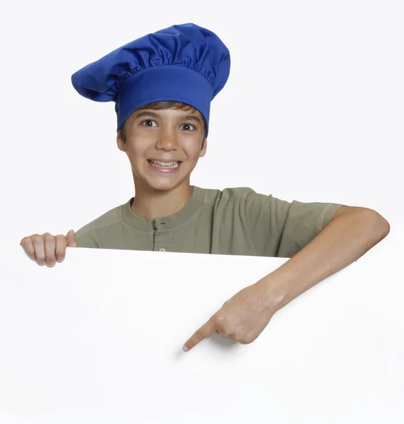 Pequeno chef criança segurando um painel branco no fundo branco . — Fotografia de Stock