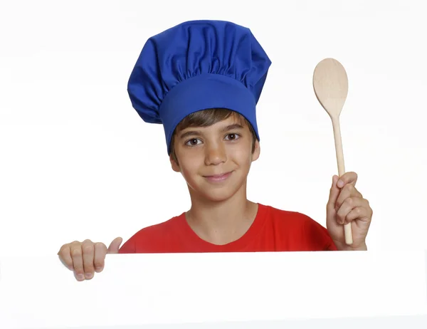 Little kid chef holding a white panel and wood spoon. — Stock Photo, Image