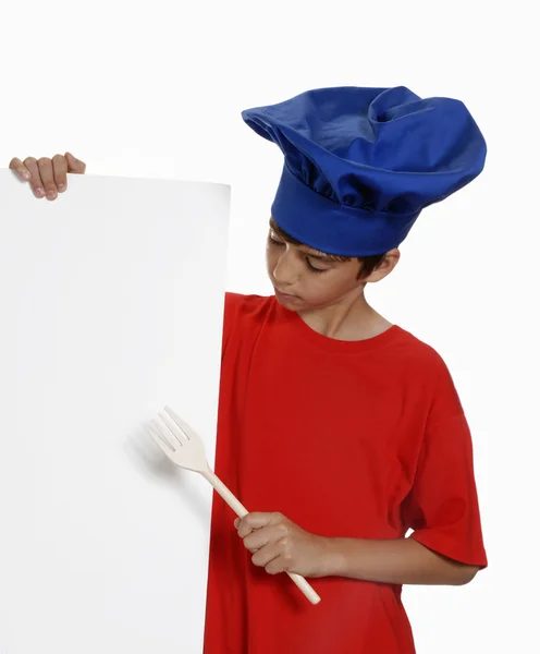 Little kid chef holding a white panel and wood spoon. — Stock Photo, Image