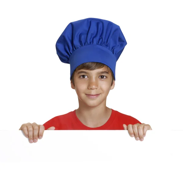 Kleine jongen chef-kok houden een witte panel op witte achtergrond. — Stockfoto