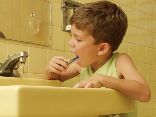 Kid escovando dentes em um banheiro . — Fotografia de Stock