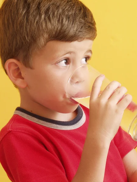 Little kid drinking a glass of water. — Stock Photo, Image