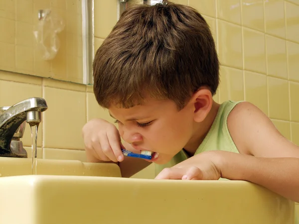 Kid escovando dentes em um banheiro . — Fotografia de Stock