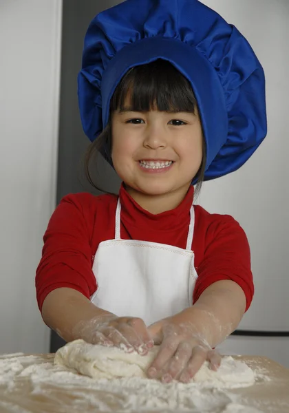 Niña cocinando una pizza en una cocina.Niña en una cocina.Niña cocinando una pizza en una cocina.Niña en una cocina . —  Fotos de Stock