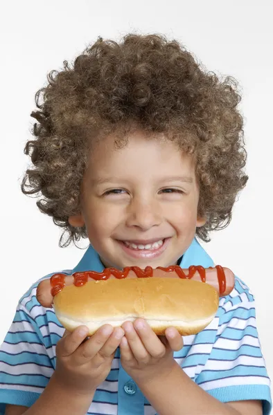 Ragazzino che mangia hot dog, Ragazzino che tiene hot dog . — Foto Stock