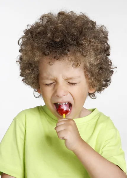 Little kid eating a lollipop portrait. — Stock Photo, Image