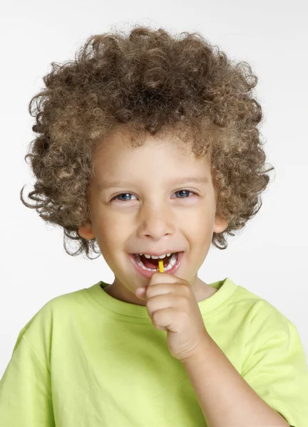Liten unge äta en slickepinne porträtt. — Stockfoto