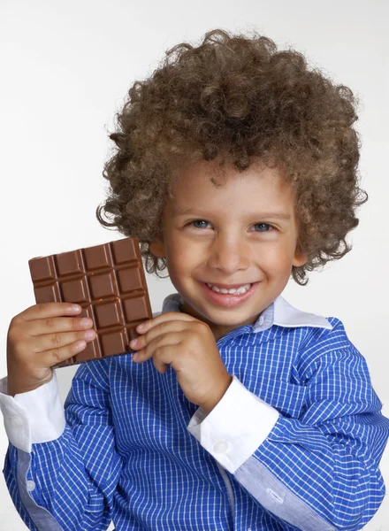 Klein kind eten van chocolade, chocolade bar bedrijf. — Stockfoto