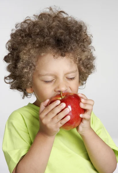 Kleines Kind hält einen roten Apfel in der Hand und isst Apfel. — Stockfoto