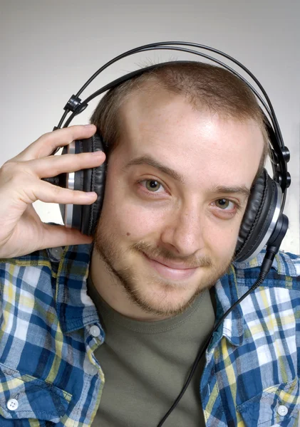 Молодий чоловік використовує навушники, слухає музику . — стокове фото