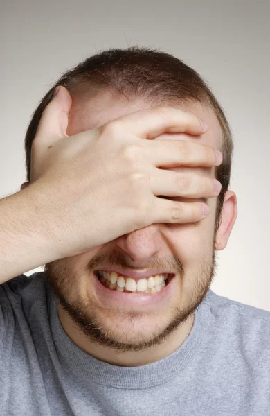 Jovem expressivo cobrindo seus olhos . — Fotografia de Stock