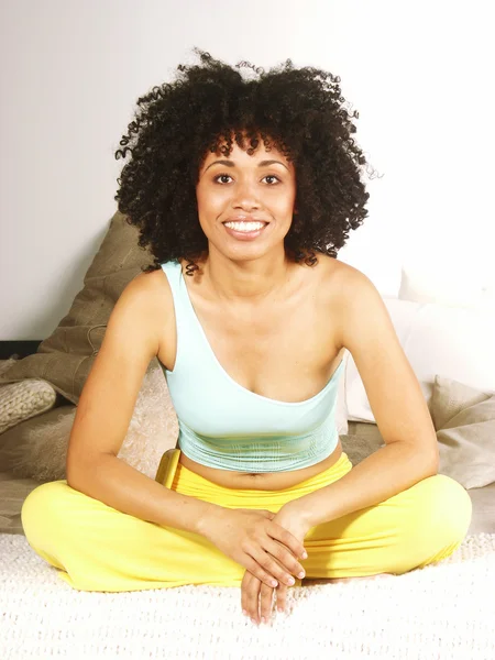 Fiatal afro-amerikai nő, egy ágyon. — Stock Fotó