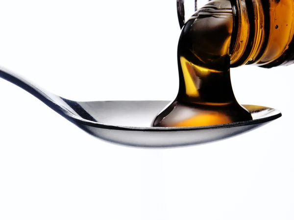 Pouring honey on a spoon — Stock Photo, Image