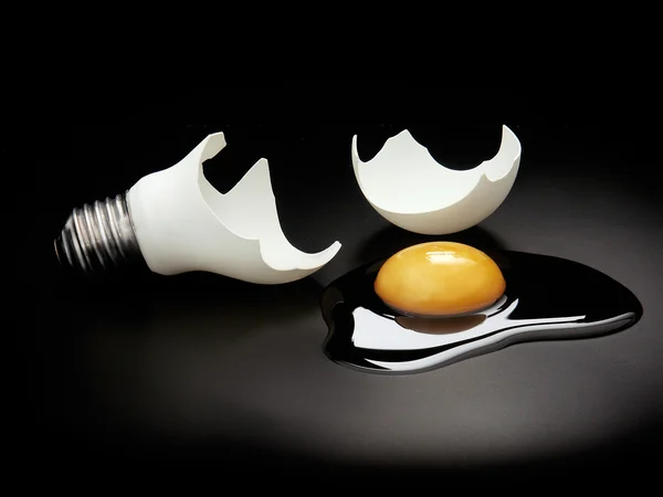 壊れた卵の黄身と電球 — ストック写真