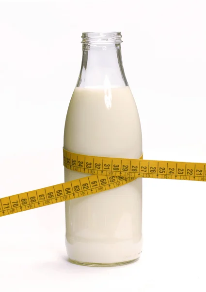 Láhev mléka s měřicí páska — Stock fotografie