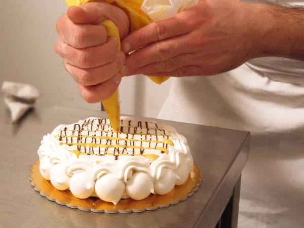 シェフの手準備中の白いチョコレートおよびクリームのケーキ — ストック写真