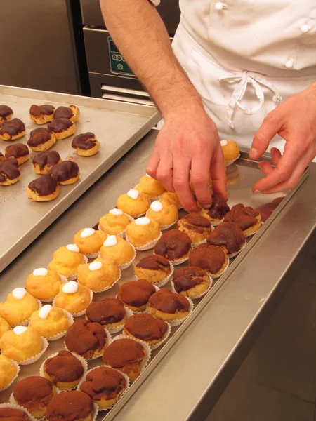 Chef-kok voorbereiden en organiseren van cupcakes — Stockfoto