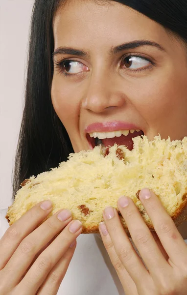 Hispanic young woman eating panettone,Young woman eating bread. — Stock Photo, Image