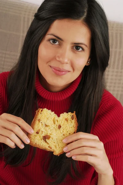 Hiszpanin kobieta młody jedzenie panettone, młoda kobieta jedzenie chleba. — Zdjęcie stockowe