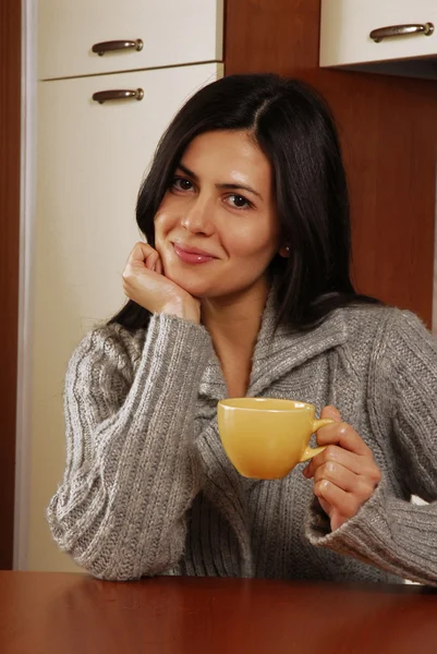 Spansktalande ung kvinna dricker kaffe eller te hemma. — Stockfoto