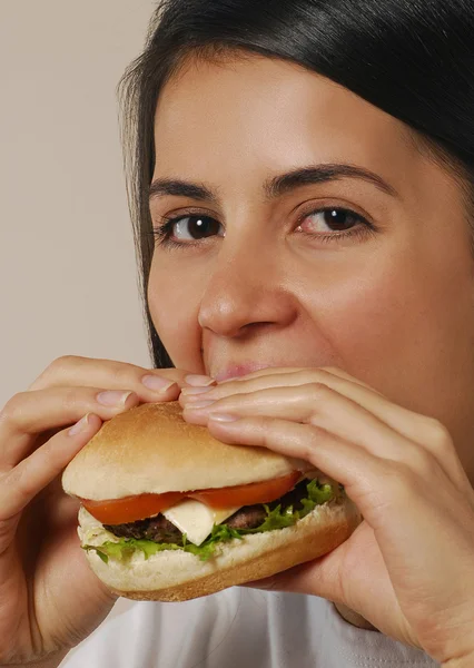 Ung kvinna äter hamburgare. — Stockfoto