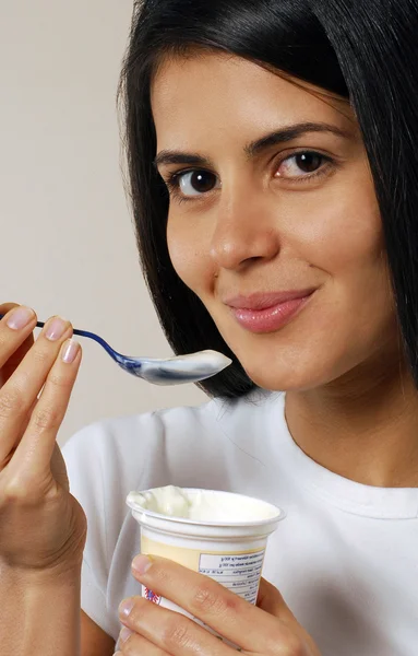 Jonge vrouwelijke genieten van en het eten van yoghurt. — Stockfoto