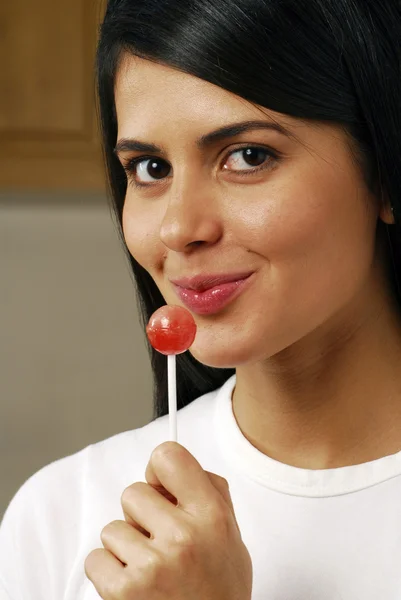 Ung kvinna äta lollipop. — Stockfoto