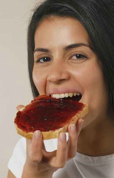 Junge Frau isst Marmelade-Toast. — Stockfoto