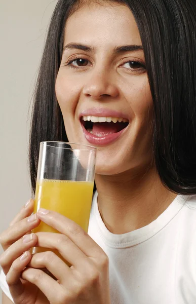 Ung kvinna dricker apelsinjuice. — Stockfoto