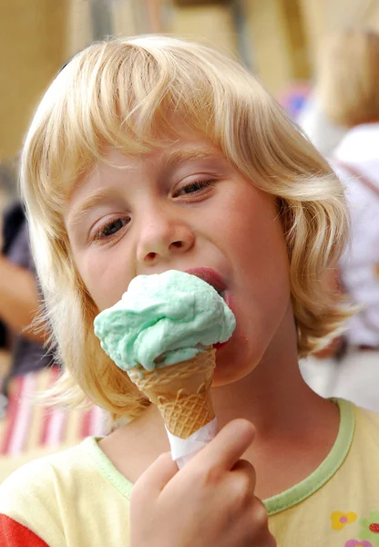 Снаружи маленькая блондинка ест мороженое . — стоковое фото