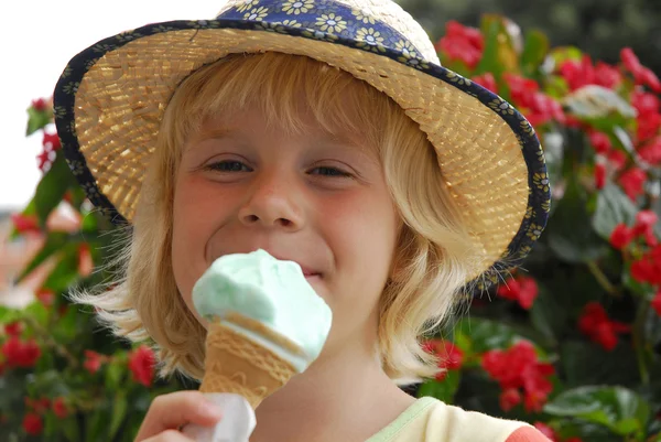 外の金髪の少女がアイスクリームを食べる. — ストック写真