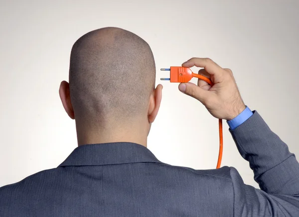 Rear view from a bald man holding an electric cable.plugging cable. — Stock Photo, Image