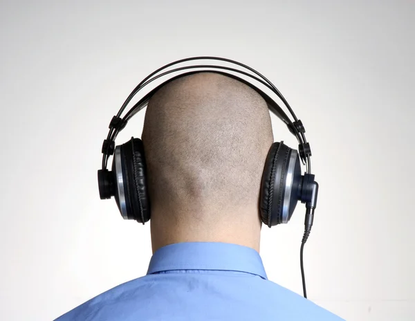 Vista trasera desde un hombre calvo adulto usando auriculares . — Foto de Stock