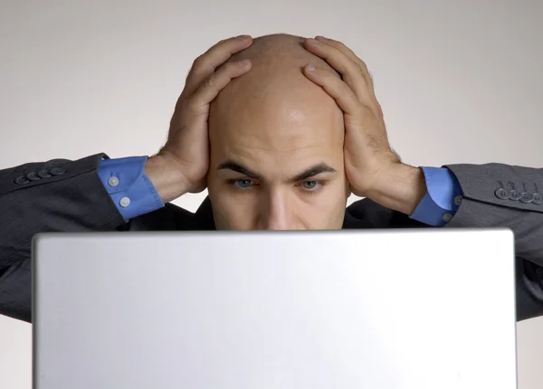 在计算机上工作的压力和困惑秃子头男子. — 图库照片