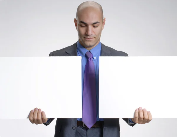 Young businessman holding two white panels. — Stock Photo, Image